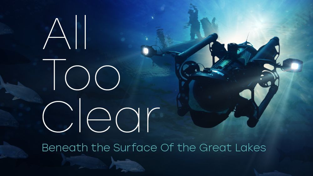 Promotional image with text “All Too Clear – Beneath the Surface Of the Great Lakes,” showing an underwater drone equipped with lights exploring beneath the water, surrounded by fish in a deep blue aquatic scene.
