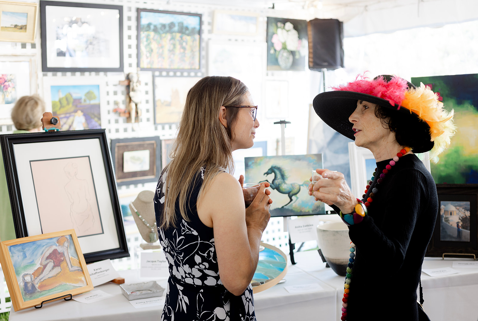 Guests enjoying the Dart for Art Gallery, which included 200+ original works of art donated by local and national artists. Featuring Carolyne Stolzenfels (left) and Rachel Goodstein (right).